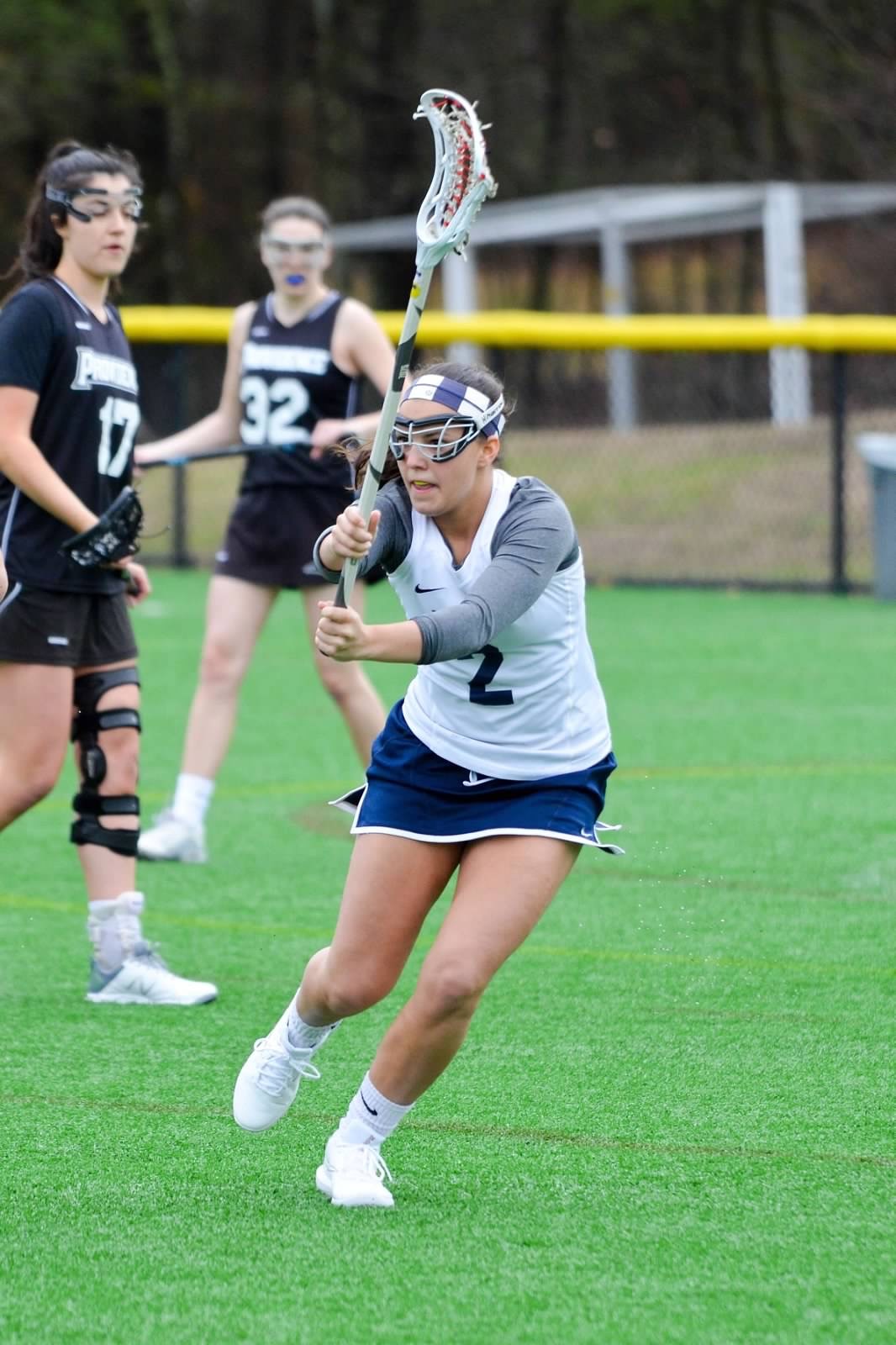UNH women's club lacrosse player running
