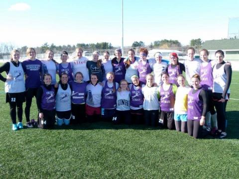 A team shot of the Women's Ultimate Frisbee team on a field at UNH.
