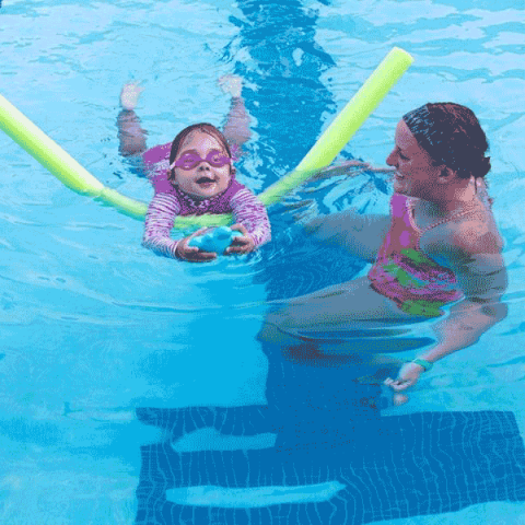 child in pool with instructor for swim lesson
