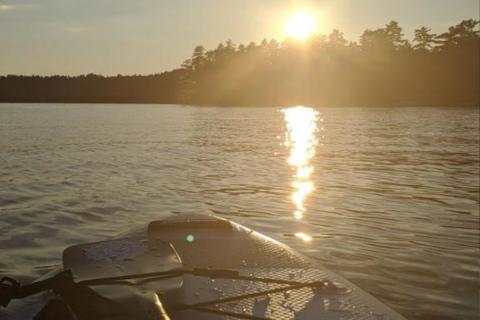 paddleboard on lake with sunset