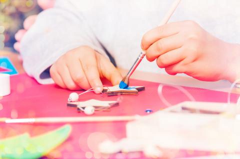 Child painting a blue wooden star