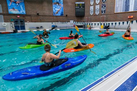 People kayaking in indoor pool.