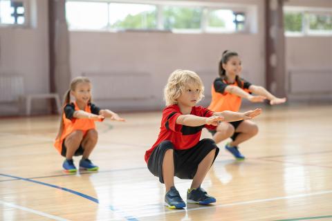 Three kids doing squat exercises.