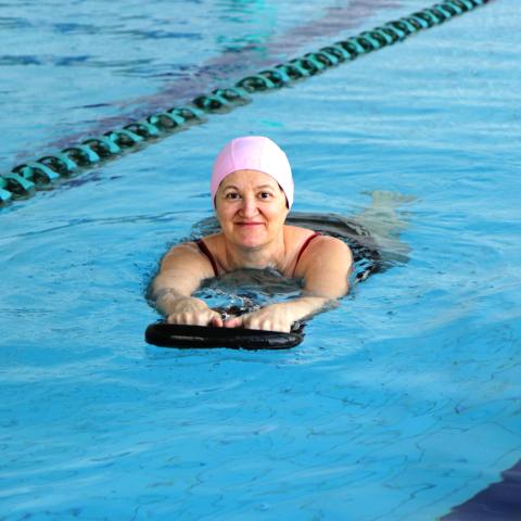 Adult using paddleboard in pool. 